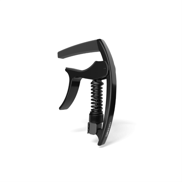The image shows a black, spring-loaded clamp-style guitar capo with a curved mechanism, padded bar, and ergonomic handle for one-handed use. Made from metal and rubber or silicone, it features a sleek, modern design. This accessory clamps across the fretboard to raise string pitch, allowing guitarists to change keys easily while maintaining chord shapes. It appears to be a high-quality, professional-grade model.