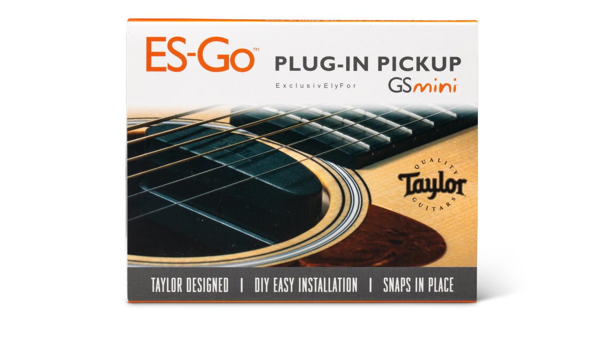 The image shows packaging for the Taylor ES-Go™ Plug-In Pickup, designed exclusively for Taylor GS Mini guitars. The box highlights Taylor design, easy DIY installation, and a snap-in-place feature. It also features a close-up photo of a Taylor acoustic guitar's sound hole, strings, and natural wood finish. This pickup system allows players to amplify their acoustic GS Mini guitar without permanent modifications.