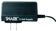 The image shows a black SNARK 9 Volt power supply adapter for musical instruments. It features "SNARK" and "9 Volt Supply" branding, wall plug prongs, and a power cable to connect electronic music gear. This adapter powers effects pedals, tuners, and other 9-volt devices, providing reliable power and eliminating the need for batteries.