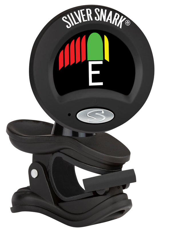 The image shows a Snark Silver Snark clip-on electronic guitar tuner with a black plastic body attached to a guitar headstock. It features a digital display indicating the note "E" with a multicolor LED strip for tuning feedback. The adjustable, rotatable head allows optimal viewing, and Snark branding is visible. The chromatic tuner detects vibrations for accurate, easy tuning during practice or performance.