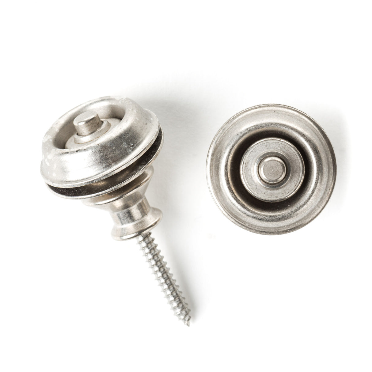 A pair of guitar straplocks with a vintage nickel finish on a white background