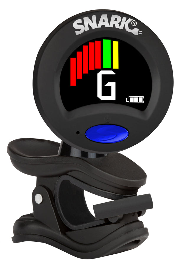 The image shows a Snark clip-on chromatic guitar tuner with a circular black housing and the "SNARK" logo at the top. It has a digital display featuring a colorful tuning meter with red, yellow, and green bars, the letter "G" for the string being tuned, and a battery icon. A blue button is on the front, and a black clip attaches it to a guitar headstock, detecting string vibrations for accurate tuning.