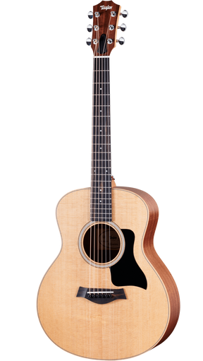 The image shows a Taylor steel-string acoustic guitar with a natural spruce or cedar top and darker mahogany or sapele back and sides. It features a mid-sized Grand Auditorium body, chrome tuning machines, a dark wood bridge with a compensated saddle, a round soundhole with a rosette, and a black pickguard. The natural finish highlights the wood grain, reflecting Taylor’s quality craftsmanship and versatile playability.
