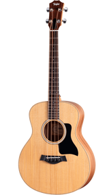 The image shows a Taylor 4-string acoustic bass guitar with a natural wood finish. It features a dark wood headstock with the Taylor logo and chrome tuners, a dark fingerboard with dot markers, a round sound hole with a decorative rosette, a black pickguard, and a dark wood bridge likely with an integrated pickup. This high-quality instrument is known for its warm, mellow tone ideal for unplugged and recording use.