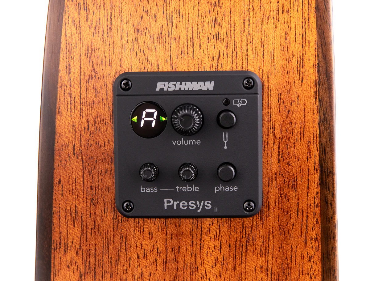 The image shows a Fishman Presys II acoustic guitar preamp system installed in the side of a guitar. Visible features include a digital tuner display, volume knob, bass and treble EQ controls, phase switch, low battery indicator, and the Fishman branding. This onboard preamp allows acoustic guitarists to amplify and shape their tone while providing a built-in tuner for live or recording use.