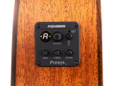 The image shows a Fishman Presys II acoustic guitar preamp system installed in the side of a guitar. Visible features include a digital tuner display, volume knob, bass and treble EQ controls, phase switch, low battery indicator, and the Fishman branding. This onboard preamp allows acoustic guitarists to amplify and shape their tone while providing a built-in tuner for live or recording use.