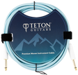 The image shows a Teton Guitars Premium Woven Instrument Cable with a light blue/turquoise woven fabric exterior for durability and style. It has gold-plated 1/4" connectors on both ends for optimal signal transfer. The packaging features the Teton Guitars logo and mountain design. The cable is coiled and secured with velcro straps, highlighting its quality build ideal for electric guitars and basses.