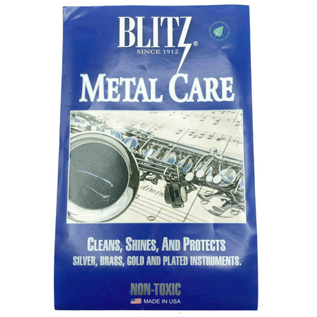 The image shows a package of Blitz Metal Care, a non-toxic cleaning and polishing solution for metal musical instruments. Established in 1912, Blitz’s Metal Care is designed to clean, shine, and protect silver, brass, gold, and plated instruments. The packaging features a saxophone and sheet music, highlighting its use for brass and metal wind instruments. Made in the USA, it’s essential for instrument maintenance.