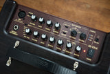 The image shows a BOSS AC-22LX acoustic guitar simulator and effects processor. It features XLR mic input with phantom power, instrument input, various outputs, and controls for mic volume and tone, guitar volume, EQ, reverb, a rhythm box with pattern, volume, tempo controls, and a looper with record/play/dub functions. It includes master volume, power switch, and built-in rhythm patterns for live and recording use.