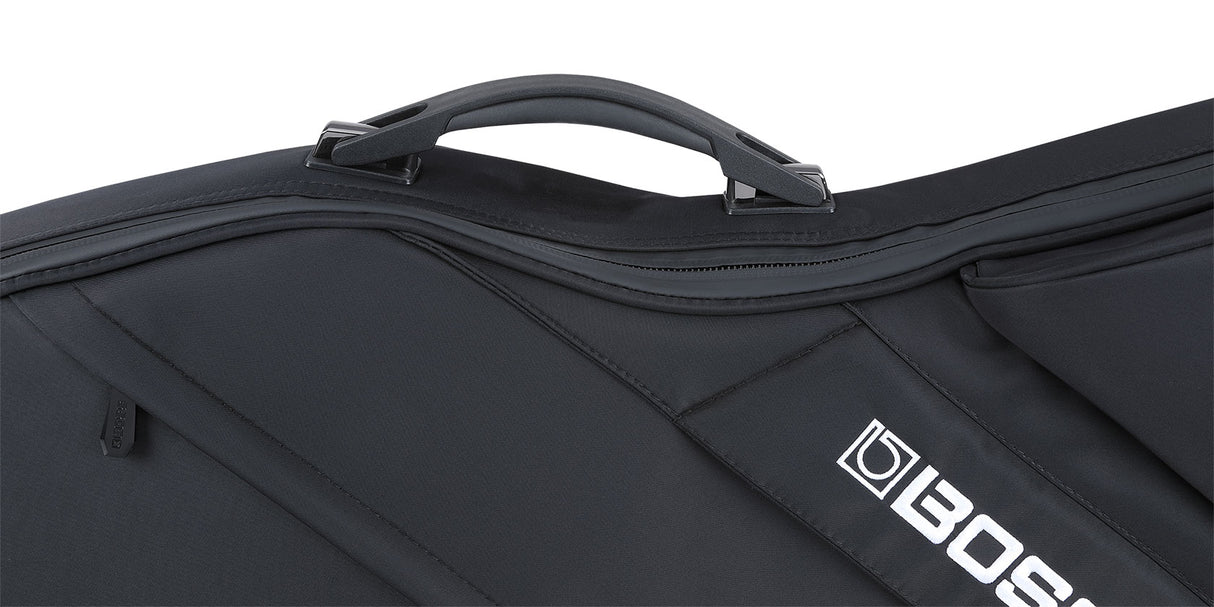 The image shows a black, soft-sided padded musical instrument gig bag with a sturdy top handle and multiple zippered compartments. It features reinforced stitching and the "BOSS" logo on the lower right corner. Designed for professional use, it likely protects electronic musical equipment such as keyboards or guitars, reflecting BOSS's reputation for electronic music gear. The sleek all-black design offers a protective and professional appearance.