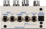 The image shows a Model DD-200 guitar effects pedal, a digital delay unit. It features four chrome control knobs, stereo A/MONO and B input/output jacks, CTL 1,2/EXP jack for external control, and a DC IN power jack. The pedal has a white/cream metal enclosure with blue labeling, designed for advanced delay effects with extensive parameter control and professional build quality.