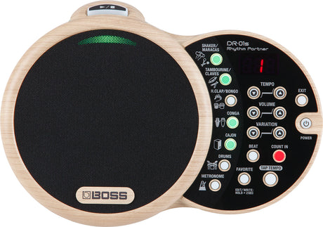 The image shows a BOSS DR-01S Rhythm Partner, an electronic drum machine with a distinctive dual-circle light wood design. The left side features a large mesh practice pad with the BOSS logo. The right side has a control panel with percussion instrument buttons, LED indicators, tempo, volume, variation knobs, function buttons, power, exit, and a small LCD display. It’s designed for rhythm creation and practice.