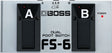 The image shows a Boss FS-6 Dual Foot Switch, a guitar accessory with two labeled foot switches (A and B), each with red LED indicators, and a power LED on the right. It features a metal body with black rubber pedals, the Boss logo in the center, and a top diagram showing switching options. Used by musicians to control amps or effects pedals hands-free during performance.