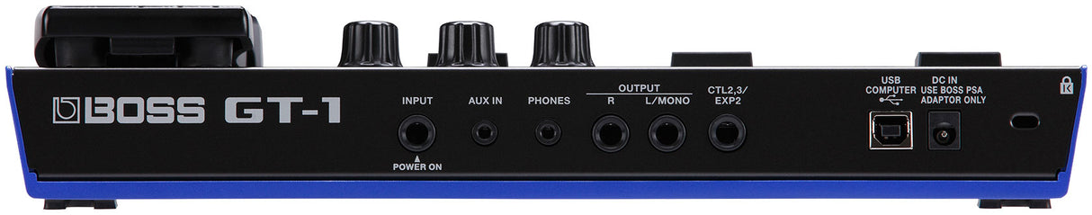 The image shows a BOSS GT-1 guitar effects processor, a compact multi-effects pedal from BOSS (Roland). It features guitar input, AUX IN, headphone out, main outputs, control jacks, USB port, DC power input, and a power switch. The top panel has three rotary knobs. Designed for versatile guitar effects, amp modeling, and sound processing, the GT-1 is ideal for practice, recording, and live use.