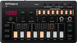 The image shows a Roland J-6 Chord Sequencer, a compact desktop synthesizer and music production tool. It features a digital tempo display (128 BPM), play/record buttons, volume knob, headphone output, and 8 lit chord slots for sequencing. Controls include filter, envelope, delay, reverb, style, and variation knobs, input/output ports, and various mode and transport buttons. Popular for creating chord progressions and backing tracks.
