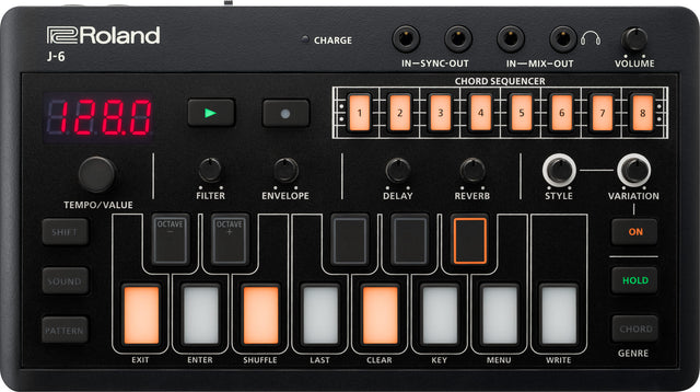 The image shows a Roland J-6 Chord Sequencer, a compact desktop synthesizer and music production tool. It features a digital tempo display (128 BPM), play/record buttons, volume knob, headphone output, and 8 lit chord slots for sequencing. Controls include filter, envelope, delay, reverb, style, and variation knobs, input/output ports, and various mode and transport buttons. Popular for creating chord progressions and backing tracks.