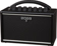 The image shows a BOSS Katana guitar amplifier by Roland, featuring a compact black design with the BOSS logo and Japanese katana symbol on the speaker grille. Visible are the control panel with knobs for gain, volume, EQ, and effects, a sturdy top handle for portability, and a protective speaker grille. This small, versatile amp is known for quality modeling and built-in effects, ideal for practice, recording, or small venues.