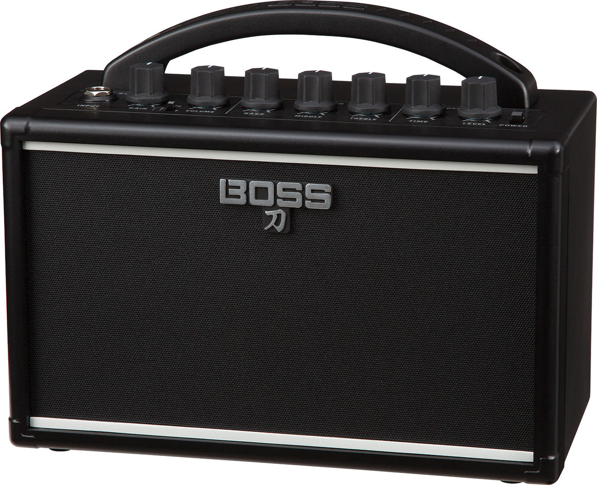 The image shows a BOSS Katana guitar amplifier by Roland, featuring a compact black design with the BOSS logo and Japanese katana symbol on the speaker grille. Visible are the control panel with knobs for gain, volume, EQ, and effects, a sturdy top handle for portability, and a protective speaker grille. This small, versatile amp is known for quality modeling and built-in effects, ideal for practice, recording, or small venues.