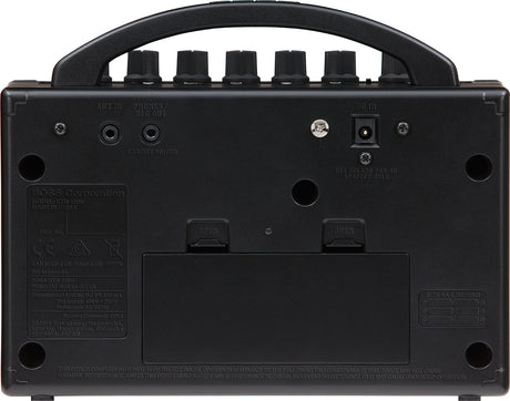 The image shows the back panel of a BOSS Katana Mini (KTN-MINI) guitar amplifier, featuring AUX IN and PHONES/REC OUT jacks, a DC power input, a USB port, ventilation holes, regulatory labels, and rubber feet. This compact amplifier supports silent practice with headphones, playing along via auxiliary input, and USB connectivity for recording or updates.