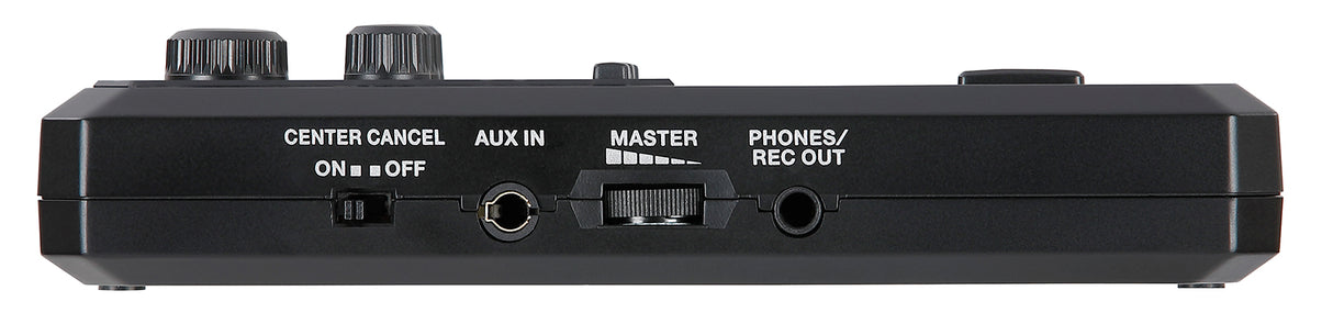 The image shows a compact, black audio effects pedal with two large knobs, a "CENTER CANCEL" switch, an "AUX IN" jack, a "MASTER" level knob, and a "PHONES/REC OUT" jack. White labels identify controls on its rectangular housing. It appears to be a vocal or karaoke processor designed to reduce lead vocals and support practice, recording, or performance with various audio sources.