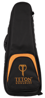 The image shows a Teton Music ukulele gig bag in black with orange trim. It features a padded, soft-sided design with a zippered closure and a front pocket displaying the "TETON UKULELES" logo. The bag has a teardrop shape tailored for a ukulele, providing lightweight protection and convenient storage for transporting the instrument.