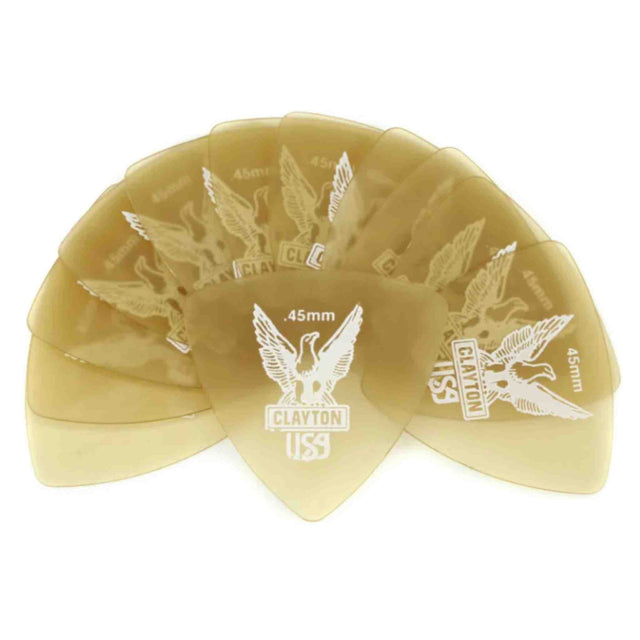 The image shows a fan of translucent amber Clayton guitar picks engraved with spread-wing eagle designs. Visible markings include "CLAYTON," "USS," and thicknesses like ".45mm" and ".46mm." Multiple picks have similar eagle motifs with varying specifications. These are guitar accessories used for strumming and picking strings.