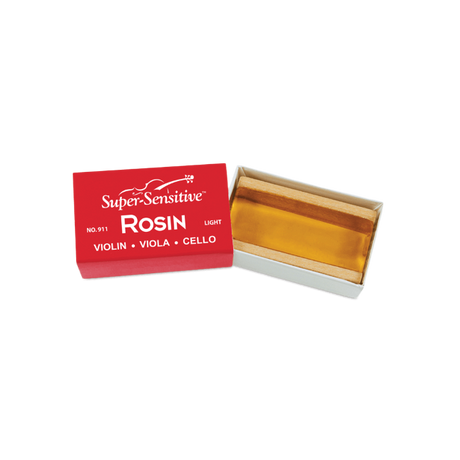 The image shows a block of "Super-Sensitive Rosin" in a light formulation, suitable for violin, viola, and cello. The translucent amber rosin is housed in red packaging labeled "Light" (No. 911). Rosin is made from tree resin and applied to bow hairs to create friction needed for sound production on string instruments. This softer rosin is preferred for warmer climates or players seeking a smoother bowing feel.