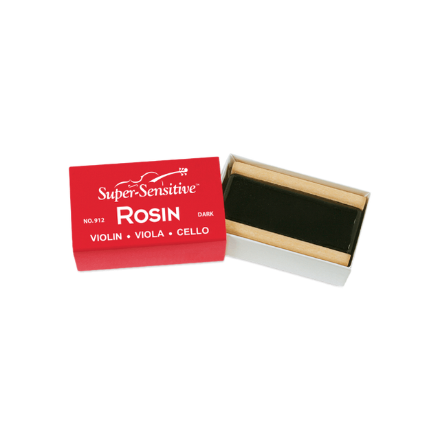 The image shows a block of "Super-Sensitive ROSIN" for violin, viola, and cello, labeled as the dark variety (No. 912). The rosin, dark amber or black in color, is housed in a small wooden or cardboard holder inside a red and white box. Rosin is essential for string instruments, applied to bow hair to create friction needed for sound when playing with a bow.