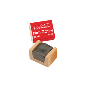The image shows a Super-Sensitive Mini-Rosin model 913D in dark rosin, housed in a small wooden case. Dark rosin is favored for lower-pitched instruments like cellos and basses due to its softer, grippier texture. This compact size is ideal for musicians seeking a portable rosin cake to apply to bow hair, enhancing friction and sound production on string instruments like violins, violas, cellos, and basses.