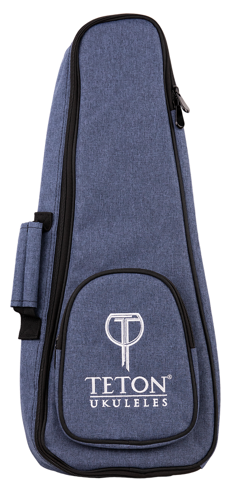 The image shows a Teton TBS25BL soprano ukulele gig bag in black. The bag features a zippered front pocket, padded shoulder straps, and a top handle for easy carrying. Its compact design is tailored to fit a soprano ukulele securely, providing protection during transport. The Teton logo is visible on the front pocket. The background is plain and the bag is displayed upright.