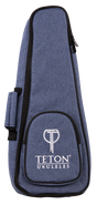 The image shows a Teton TBS25BL soprano ukulele gig bag in black. The bag features a zippered front pocket, padded shoulder straps, and a top handle for easy carrying. Its compact design is tailored to fit a soprano ukulele securely, providing protection during transport. The Teton logo is visible on the front pocket. The background is plain and the bag is displayed upright.