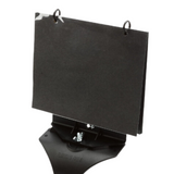 The image shows a black, adjustable tabletop music stand with a tilted reading surface. It features two metal clips at the top to hold sheet music in place. The stand has a sturdy base and is designed for musicians to easily read music while practicing or performing.