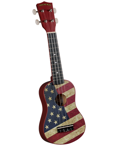The image shows a soprano ukulele with a vintage-style American flag design on the body. It has a red headstock with gold "DIAMOND HEAD" branding, four white tuning pegs, a dark fretboard with white fret markers, and four strings. The sound hole is centered. This patriotic-themed ukulele blends traditional Hawaiian style with Americana imagery, representing a Diamond Head brand instrument.