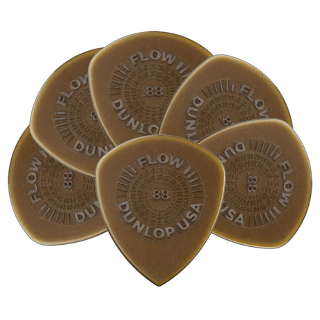 The image shows five Dunlop Flow guitar picks, each .88mm thick, made of translucent amber tortoiseshell material. They feature an ergonomic teardrop shape with "FLOW III," "DUNLOP USA," and ".88" embossed on them. These medium-heavy picks are designed for comfortable grip and versatile playing, suitable for strumming or lead guitar. Dunlop is a trusted brand known for quality guitar accessories.