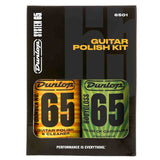 The image shows a Dunlop Guitar Polish Kit (model 6501) containing two bottles from the "65" line: Formula No. 65 Guitar Polish & Cleaner (orange) and Formula No. 65 Bodygloss "Cream of Carnauba" (green, 4 fl oz). This professional kit is designed for cleaning, polishing, and protecting guitar finishes, featuring classic Dunlop branding and the tagline "Performance is Everything." It is a trusted accessory for guitar maintenance.