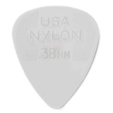 The image shows a white or light gray, teardrop-shaped guitar pick with "USA" at the top, "NYLON" in the middle, and ".38MM" at the bottom. It is a 0.38 mm thin nylon pick, made in the USA. Thin picks like this are flexible and ideal for strumming and rhythm guitar, offering a softer attack and smooth feel. Nylon is durable and provides good tone.