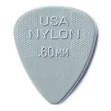 The image shows a light grayish-green nylon guitar pick with ".60MM" thickness embossed, indicating a 0.60 mm medium gauge. It features a textured crosshatch grip on both sides near the top to prevent slipping. Made in the USA, this pick balances flexibility and control, making it suitable for various playing styles. Nylon material offers durability and a balanced tone.