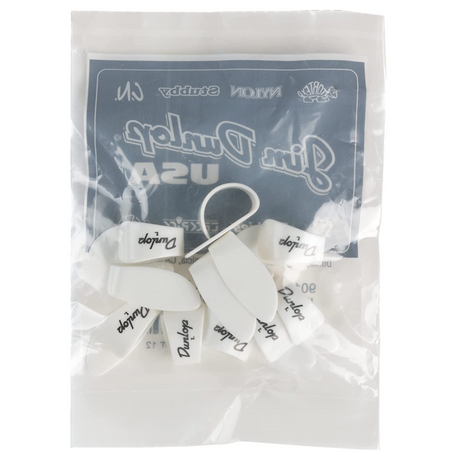 The image shows a package of Dunlop guitar picks featuring multiple white picks with "Dunlop" printed in black. The packaging has a dark blue-gray header with the Dunlop logo and branding, including text that appears to read "Gim Purple USA." The picks are displayed in a small plastic pouch, a common way they are sold. Dunlop is a well-known maker of guitar accessories.