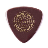 The image shows a Dunlop "Prime Tone" guitar pick with a 1.4mm thickness. It has a dark reddish-brown color and gold lettering arranged in a circular pattern: "PRIME TONE" at the top, "1.4" in the center, and "DUNLOP U.S.A." at the bottom, surrounded by decorative dots. This premium pick offers a thicker, firm feel favored by lead guitarists and players seeking greater control.