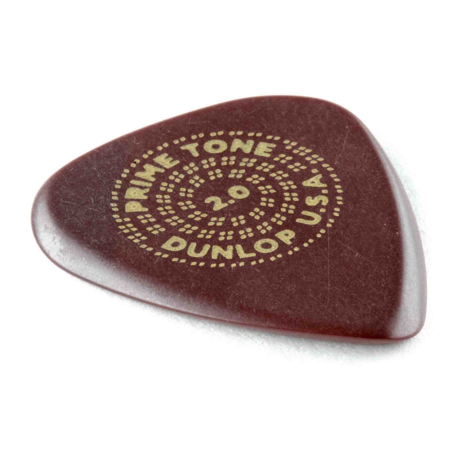 The image shows a Dunlop Primetone guitar pick, 2.0mm thick, in a dark reddish-brown color. It has a teardrop shape with a smooth, textured grip surface and a dotted circular logo. Known for premium quality, this thick pick offers enhanced control and tone, favored by jazz guitarists and players who prefer substantial picks.