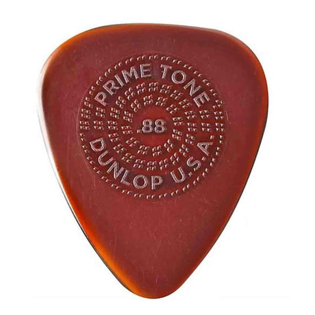The image shows a Dunlop Primetone guitar pick in translucent amber/tortoiseshell color. It has embossed circular text: "PRIMETONE" at the top, "DUNLOP" at the bottom, "USA" on the right, and "88" in the center, likely indicating thickness. Known for premium materials, a sculpted tip, and embossed grip, it offers precision, tone, and durability favored by professional guitarists.
