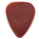 The image shows a Dunlop Primetone guitar pick, 1.3mm thick, in amber/tortoiseshell color. It features embossed circular text: "PRIME TONE" at the top, "1.3" in the center, "DUNLOP" at the bottom, and "U.S.A." on the side. Known for its smooth surface, durable build, and textured grip, this medium-heavy pick offers control and comfort, popular among guitarists across various genres.