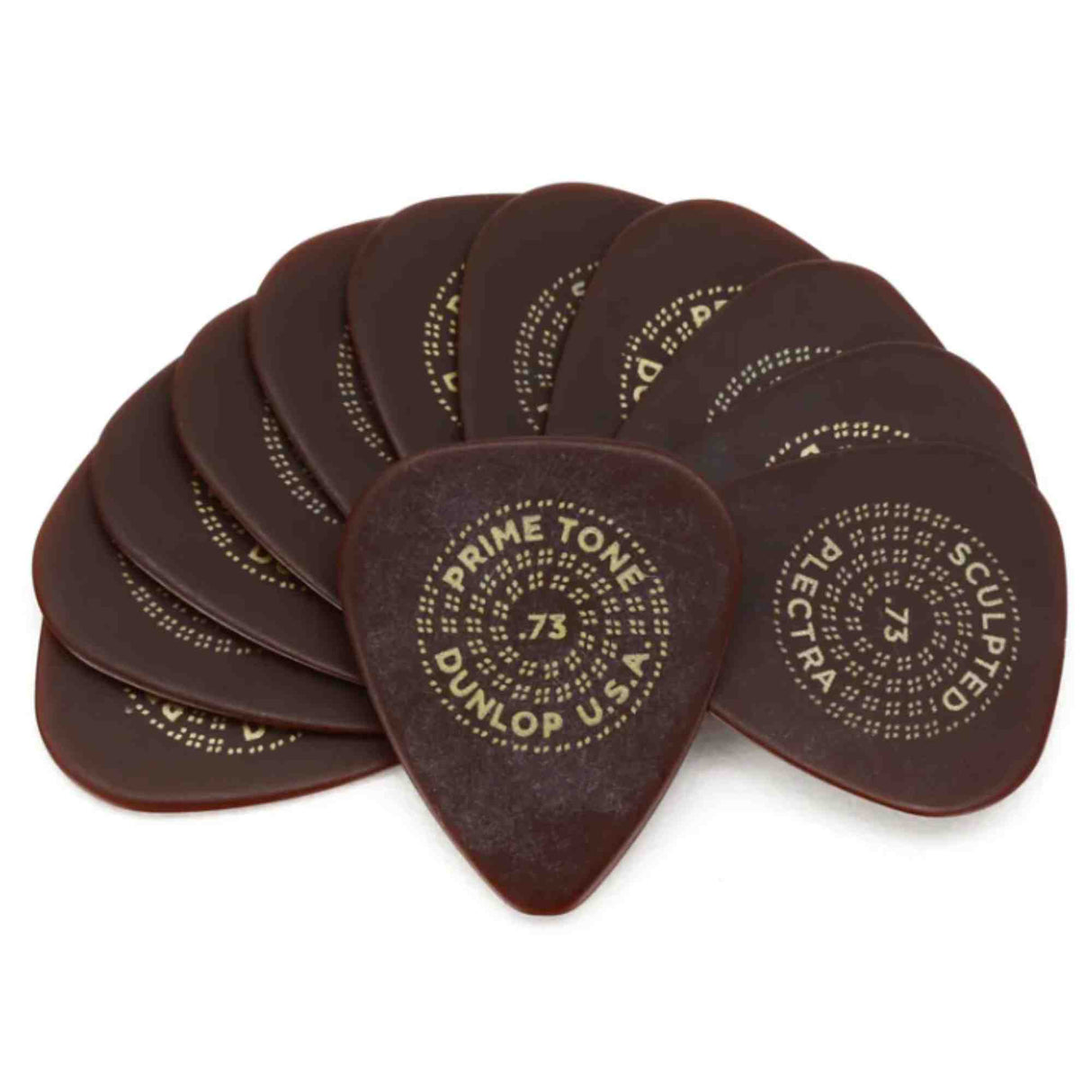 The image shows a collection of dark brown, tortoiseshell Dunlop guitar picks with gold dotted text patterns. The picks feature "PRIMETONE" and ".73," indicating the thickness gauge. These premium, vintage-inspired picks have elegant stippled lettering. Guitar picks are essential for plucking or strumming and come in various thicknesses and materials to suit different playing styles.