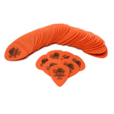 The image shows a large collection of orange Dunlop Tortex guitar picks arranged in a curved formation, with several individual picks in the foreground. Each pick features the black Dunlop logo. These .60mm picks offer medium flexibility, popular for both strumming and picking, and are known for durability and grip. This appears to be a bulk pack or dealer display.