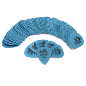 The image shows a large collection of blue Dunlop guitar picks arranged in a curved, fan-like pattern. Several picks are displayed in front, clearly showing the Dunlop logo and text. The picks are a consistent blue/teal color and appear to be medium gauge, commonly used by guitarists. This typical product photo highlights essential guitar accessories.