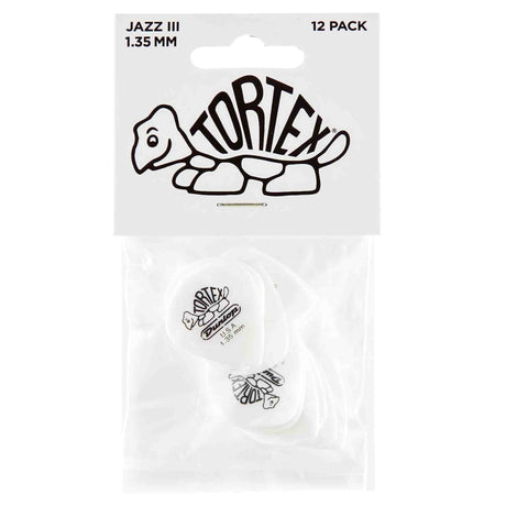 The image shows a 12-pack of Dunlop Tortex Jazz III guitar picks, each 1.35mm thick. The packaging displays the Tortex turtle logo, visible on the white/clear picks inside. Known for durability and grip, these small, pointed Jazz III picks offer precise control and a bright attack, favored by lead guitarists and players seeking a firm, fast-playing pick.