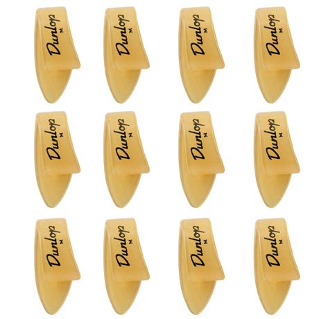 The image shows 12 Dunlop guitar picks arranged in a 3x4 grid. Each pick features the Dunlop logo and an "M," indicating medium thickness. They have a classic teardrop shape with pointed tips and are made of translucent amber-colored material, likely celluloid. These picks are popular guitar accessories used for strumming and picking, known for quality and precision.