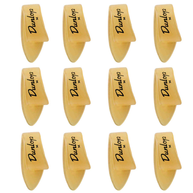The image shows 12 Dunlop guitar picks arranged in a 3x4 grid. Each pick features the Dunlop logo and an "M," indicating medium thickness. They have a classic teardrop shape with pointed tips and are made of translucent amber-colored material, likely celluloid. These picks are popular guitar accessories used for strumming and picking, known for quality and precision.