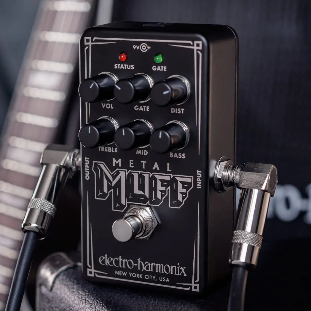 A lifestyle shot of the Electro-Harmonix Nano Metal Muff guitar pedal with instrument cables plugged into the unit.
