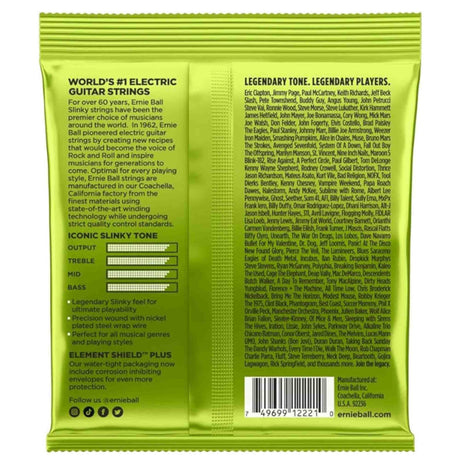 The image shows the back of a bright green Ernie Ball Slinky electric guitar strings package. It highlights the "World’s #1 Electric Guitar Strings" with 60+ years of heritage, made in Coachella, CA. Features include nickel-plated steel wrap wire, "Element Shield Plus" corrosion protection, and a frequency response chart. The package also lists famous users like Eric Clapton and Jimmy Page, along with a barcode and social media info.
